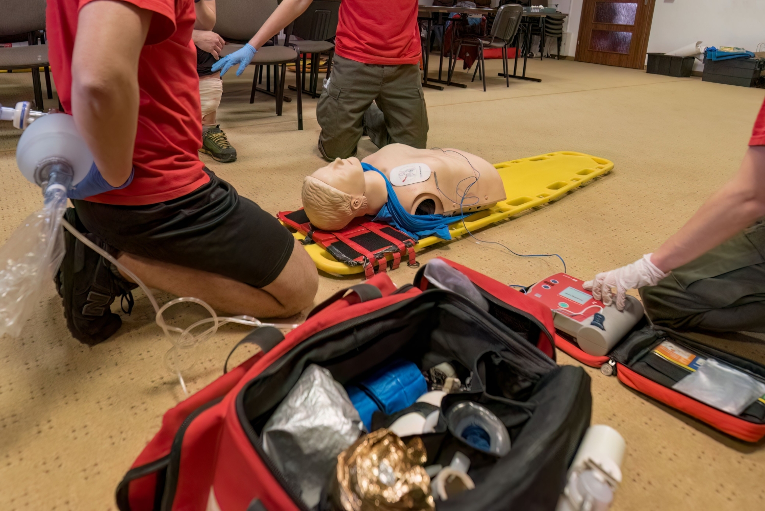 Closeup of medical professionals performing CPR on a mannequin on the floor